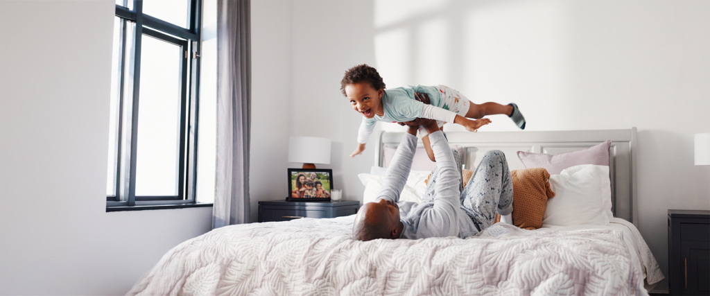 dad flying son on bed