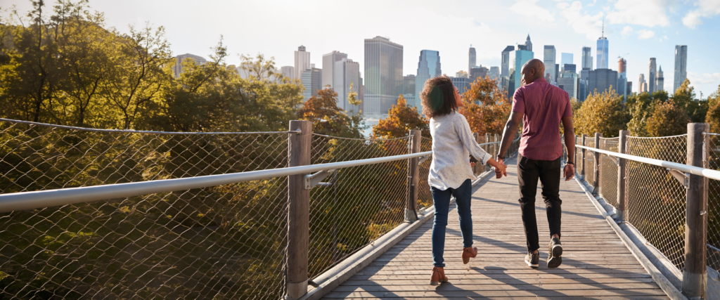 couple walking across bridge in new york city