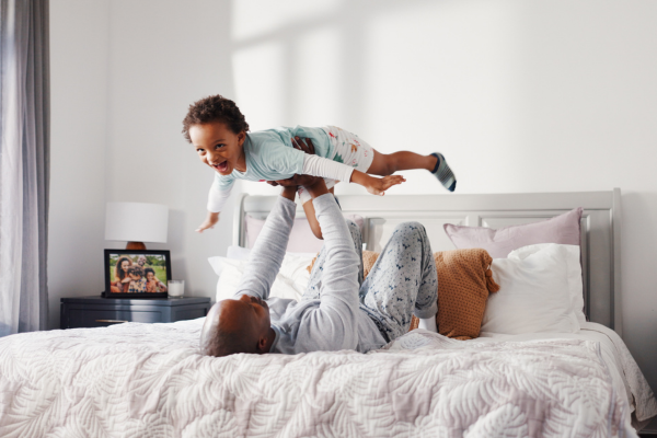 dad flying son on bed